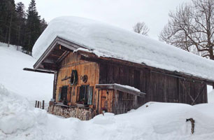 A mountain hut surrounded by deep winter snow