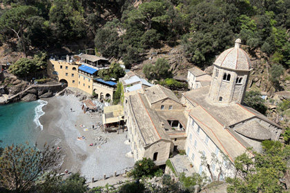 Historic Abbey of San Fruttuoso surrounded by lush green hills and turquoise waters on the Ligurian coast.