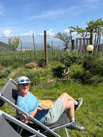Woman relaxing in a deck chair on a sunny hillside near Riomaggiore, overlooking the Ligurian Sea.