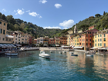 Colorful waterfront buildings and boats in the calm harbor of Portofino, Liguria, Italy