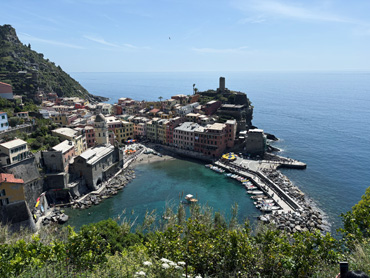 Panoramic view of Vernazza village with colorful houses, harbor, and blue sea in Cinque Terre, Italy