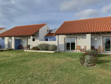 Charming cottages facing onto lawn and chairs for lounging and relaxing