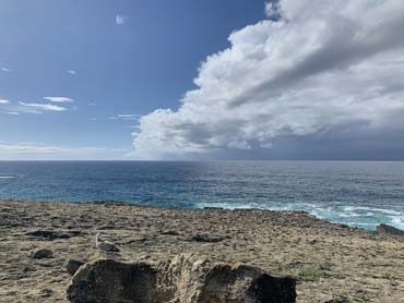 Rocky ground looking out to ocean and storm clouds rolling in